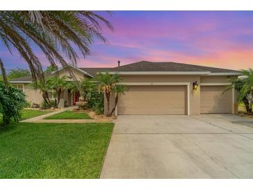 Charming single-story home featuring a fountain, a well-manicured lawn, and an attached two-car garage at 611 Curly Fern Ln, Deland, FL 32720