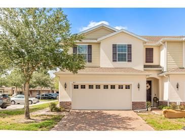 Charming townhome featuring a brick driveway and a two-car garage at 87 Delacorte Way, Oviedo, FL 32765