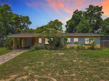 Charming single-story home with a lush front yard, mature trees, and a covered carport showcasing curb appeal at 920 Gloriosa Ave, Winter Park, FL 32789