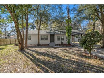 Charming home featuring a lovely front yard with mature trees and a well-maintained exterior at 11572 Se 60Th Ave, Belleview, FL 34420