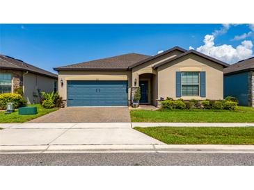 Charming single Gathering home featuring a blue garage door and shutters with a well-manicured lawn at 426 Citrus Isle Loop, Davenport, FL 33837