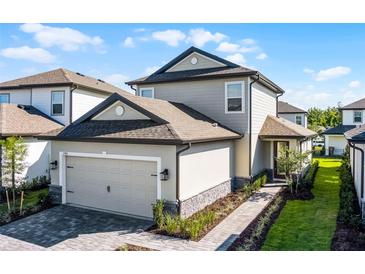Charming two-story home featuring an attached two-car garage and walkway leading to the front door at 7745 Somersworth Dr, Kissimmee, FL 34747