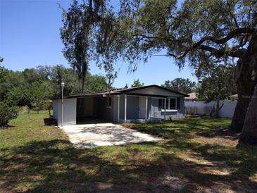 Charming single-story home with a well-manicured lawn and mature trees at 306 W Palm St, Davenport, FL 33837