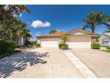 Charming home with an attached two-car garage, appealing landscaping, and a well-maintained walkway at 849 Millrace Pt, Longwood, FL 32750