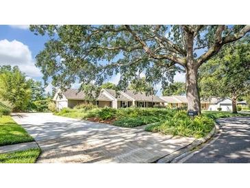 Charming single-story home with a well-maintained lawn, mature trees, and a long driveway at 1387 Sawgrass Court, Winter Park, FL 32792