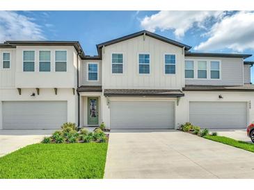 Charming townhome featuring a modern exterior, well-maintained landscaping, and a private garage at 1615 Sanibel Dr, Davenport, FL 33896