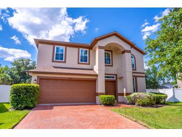 Charming two-story home featuring a brick driveway, two car garage and manicured landscaping at 1676 Song Sparrow Ct, Sanford, FL 32773