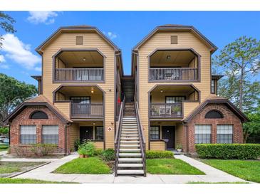 Inviting condo complex featuring multi-story buildings, beautiful landscaping, and exterior stairs at 380 Lake Ontario Ct # 201, Altamonte Springs, FL 32701