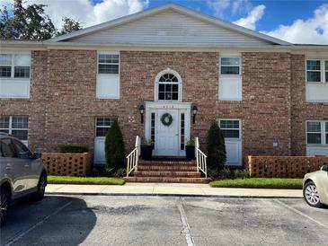 Charming brick two-story condo building featuring a welcoming front entrance and well-maintained landscaping at 4318 Lake Underhill Rd # 17A5, Orlando, FL 32803