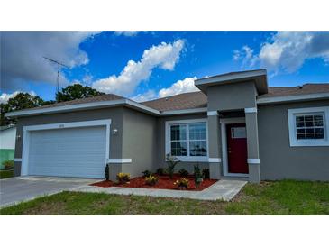 Beautiful, single-story home featuring well-kept landscaping, a two-car garage, and a stylish red front door at 475 Marion Oaks Mnr, Ocala, FL 34473