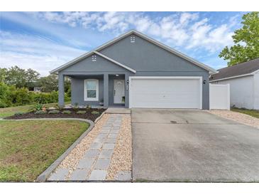 Charming single-story home with gray stucco exterior, well-manicured lawn and attached white two car garage at 7998 Harbor Bend Cir, Orlando, FL 32822