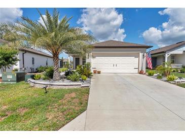 Charming single-story home featuring a two-car garage, well-manicured landscaping, and a lovely palm tree at 8413 Sw 54Th Loop, Ocala, FL 34481