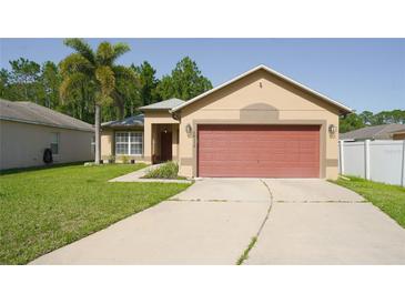 Charming single-story home with a well-manicured lawn, palm tree, and a red two-car garage at 16116 Corner Lake Dr, Orlando, FL 32820