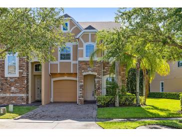 Charming two-story home featuring stone accents, a paved driveway, and lush landscaping at 2153 Cypress Villas Dr, Orlando, FL 32825