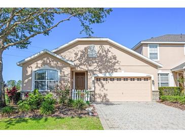Charming single-Gathering home showcasing a manicured lawn and a two-car garage at 23820 Sardinia Dr, Sorrento, FL 32776