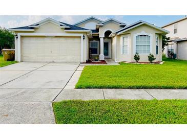 Charming one-story home featuring an attached two-car garage and well-manicured lawn at 2511 Brookstone Dr, Kissimmee, FL 34744