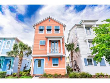 Charming peach-colored two-story home featuring blue shutters and accents with a small, decorative balcony at 3062 Pirate Way, Kissimmee, FL 34747