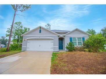 Charming single-story home with a two-car garage, landscaped yard, and welcoming entrance at 3479 Courtland Blvd, Deltona, FL 32738