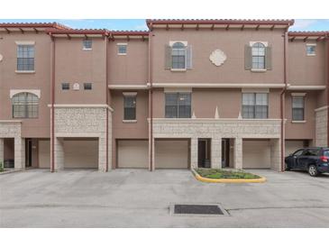Attractive townhome featuring a tandem two-car garage and classic architectural elements at 6107 Metrowest Blvd # 104, Orlando, FL 32835