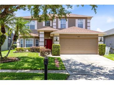 Charming two-story home with a well-manicured lawn and attached two-car garage at 14883 Hartford Run Dr, Orlando, FL 32828