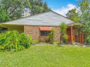 A charming home with brick and siding, complemented by lush landscaping and a welcoming entrance at 1591 Revere Ln, Daytona Beach, FL 32117