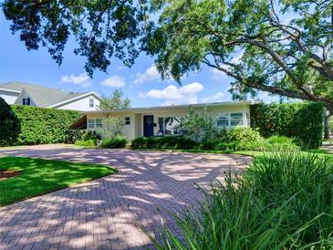 Charming single-story home featuring a brick driveway, manicured lawn, and mature landscaping at 1791 Spruce Ave, Winter Park, FL 32789