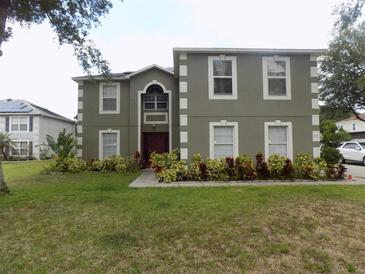 Charming two-story home with a well-maintained lawn and colorful landscaping at 2818 Sheila Dr, Apopka, FL 32712