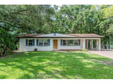 Charming single-story home with a well-maintained lawn, blue shutters, and a convenient carport at 409 E Gulley Ave, Oakland, FL 34760