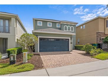 Charming home with a two-car garage and a lovely brick paved driveway, surrounded by mature landscaping at 441 Novi Path, Kissimmee, FL 34747