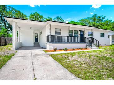 Charming one-story home featuring a covered porch, black railings, and well-maintained landscaping at 5513 Riordan Way, Orlando, FL 32808