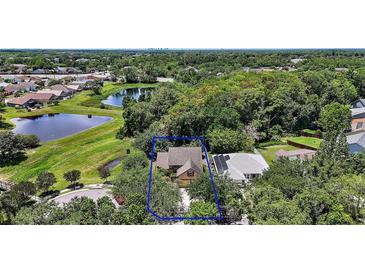 An aerial view of a cozy home surrounded by lush landscaping and a serene pond, a peaceful retreat at 612 Heron Bay Dr, Orlando, FL 32825