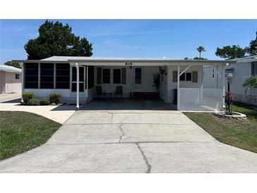 Charming single-story home with covered parking and well-maintained landscaping and beautiful blue skies at 816 Polo Park East Blvd, Davenport, FL 33897
