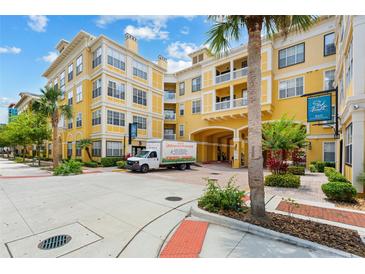 Beautiful yellow condo building with palm trees and well-maintained landscaping at Park North at Cheney Place at 860 N Orange Ave # 323, Orlando, FL 32801