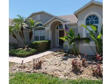Charming single-story home featuring mature palm trees and a well-maintained, colorful stone garden at 145 Henue Ct, Davenport, FL 33896