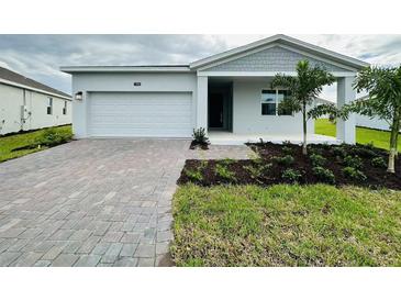 Charming single-story home with a brick driveway, well-maintained lawn, and a one car garage at 1590 Contentment Loop, Kissimmee, FL 34744
