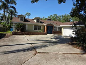 Charming home with inviting blue door and manicured front yard, showcasing curb appeal at 1695 E Horatio Ave, Maitland, FL 32751