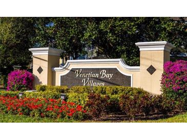 Venetian Bay Villages community sign surrounded by colorful flowers and lush greenery at 2208 San Vittorino Cir # 104, Kissimmee, FL 34741