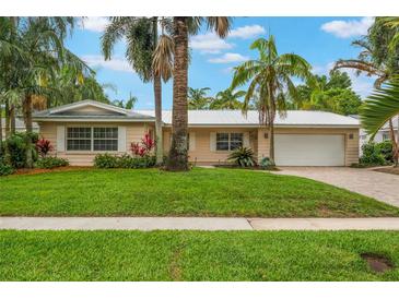 Charming single-story home featuring lush landscaping, a well-manicured lawn, and a metal roof for lasting durability at 3608 Eloise St, Orlando, FL 32806