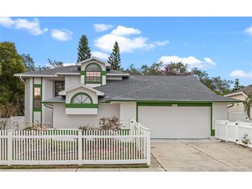 Charming two-story home featuring a well-manicured lawn and white picket fence, complemented by an attached two-car garage at 4527 Sandhurst Dr, Orlando, FL 32817
