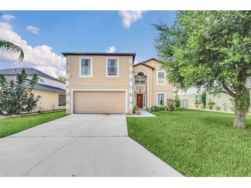 Two-story home featuring neutral siding, manicured lawn, mature trees and an attached two-car garage at 510 Lobelia Dr, Davenport, FL 33837