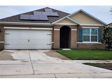 Charming single Gathering home featuring solar panels, attached two car garage, and tidy lawn at 5367 Douglas Fir Dr, St Cloud, FL 34771