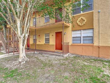 Tan two-story apartment building with a tree and a stairway at 744 Wyman Ct # 744, Orlando, FL 32809
