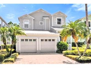 Charming two-story home features a two-car garage and mature landscaping, including palm trees at 7710 Linkside Loop, Reunion, FL 34747