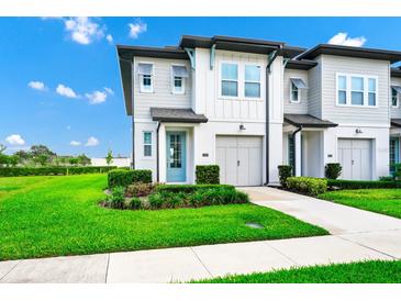 Charming two-story home features a blue front door, a two-car garage, and well-manicured landscaping at 809 Benoi Dr, Davenport, FL 33896