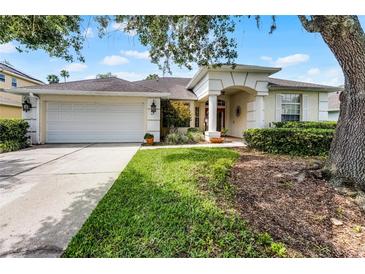 Charming one-story home with a well-manicured lawn, a two-car garage and an arched entryway at 821 Shallow Brook Ave, Winter Springs, FL 32708