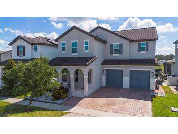 Charming two-story home with a brick driveway, archway covered porch, and a two-car garage at 9845 Emerald Berry Dr, Winter Garden, FL 34787