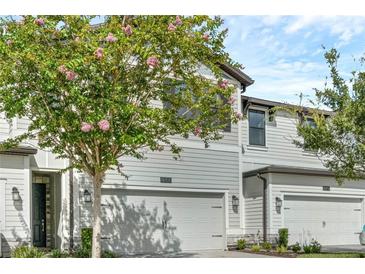 Charming townhome with a well-maintained front yard and an attached garage at 11258 Whistling Pine Way, Orlando, FL 32832