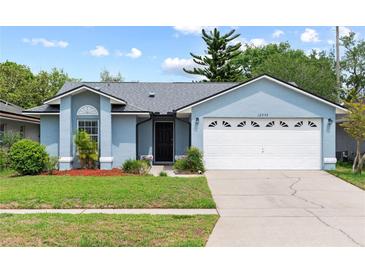 Charming one-story home with a well-manicured lawn and attached two-car garage at 12952 Downstream Cir, Orlando, FL 32828