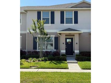 Charming townhome exterior featuring a well-maintained front lawn and decorative shutters at 1832 Katz Crossing Dr, Kissimmee, FL 34744