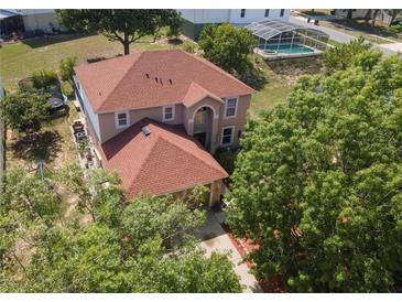 Stunning aerial view of a well-maintained home with a pool and landscaped backyard at 3216 White Blossom Ln, Clermont, FL 34711